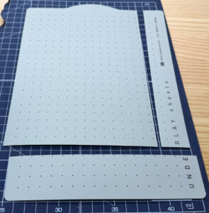 定規とカッターで下敷きをカットしている作業途中